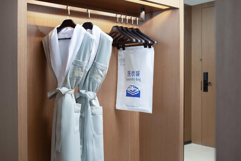 广州广州洛溪希尔顿欢朋酒店的门上带长袍和袋子的衣柜