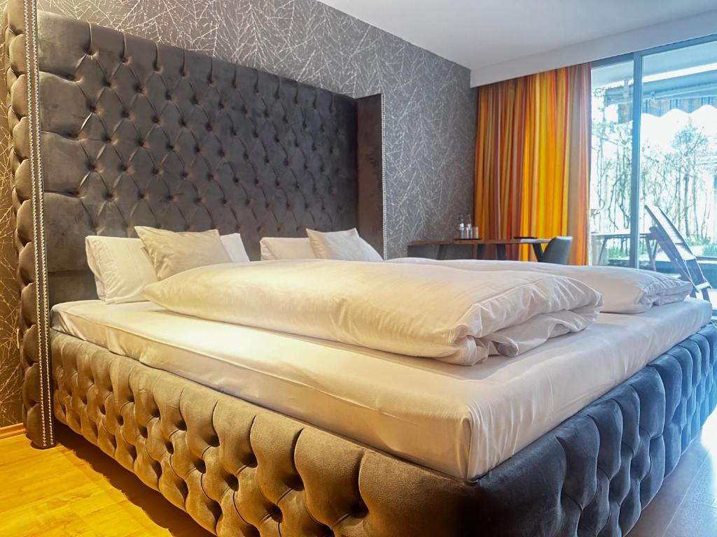 埃尔克拉特乌特菲尔豪斯酒店的卧室内的一张大床,配有大软垫床头板