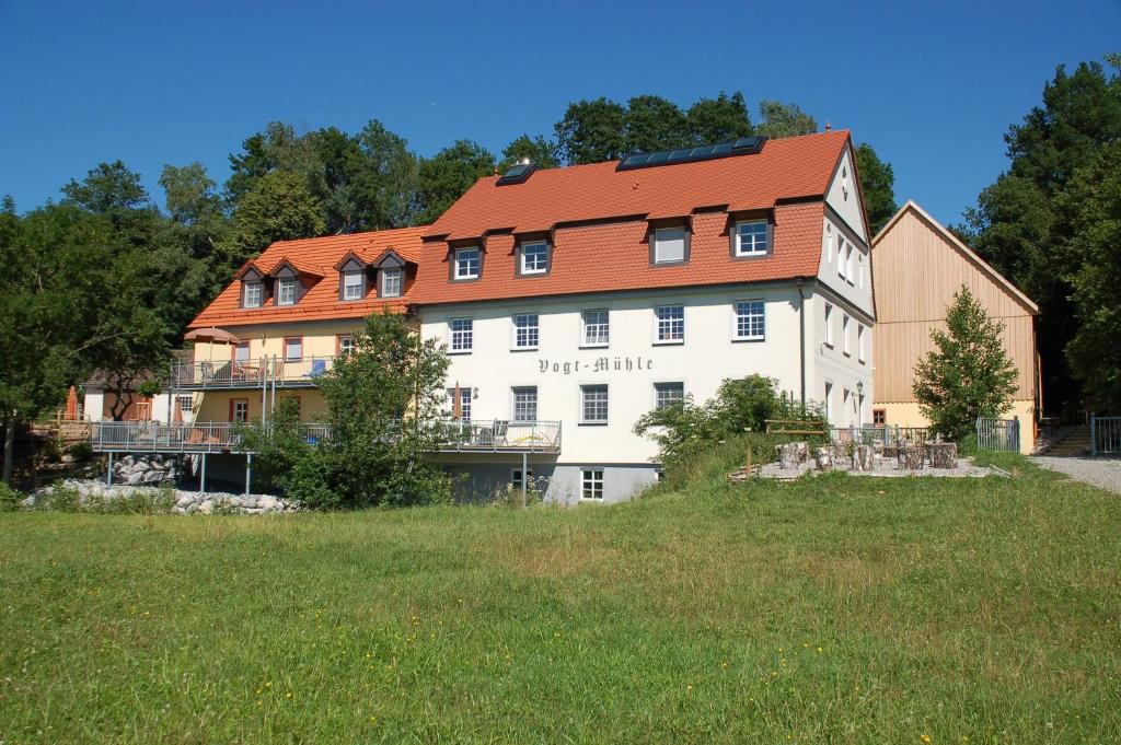 罗根伯格Vogtmühle的一座白色的大建筑,有红色的屋顶