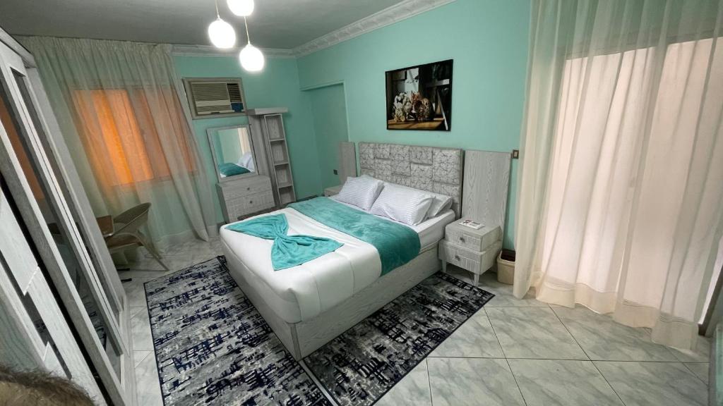 开罗New Cozy Apartment 5 Minutes away from Cairo Airport and all Amenties的一间卧室设有一张床和蓝色的墙壁