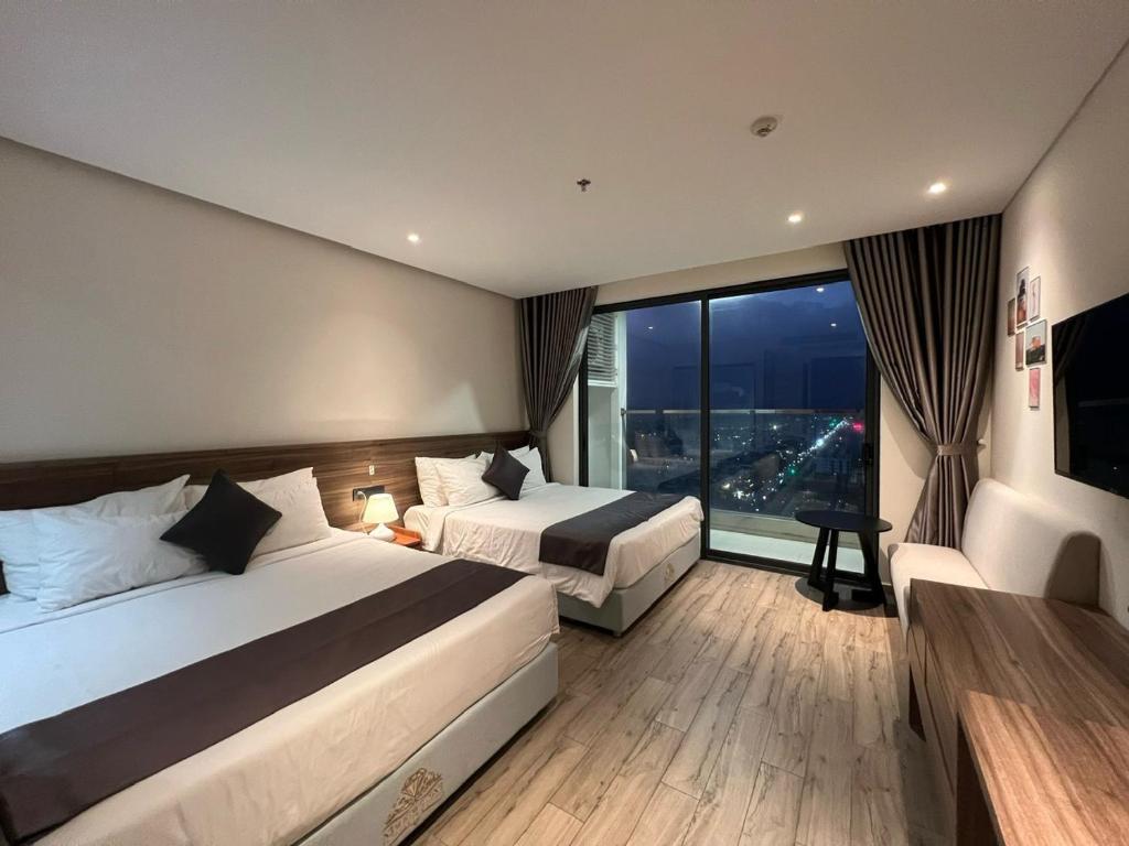 绥和市Apec Mandala Hotel Tuy Hoà的酒店客房设有两张床和大窗户。