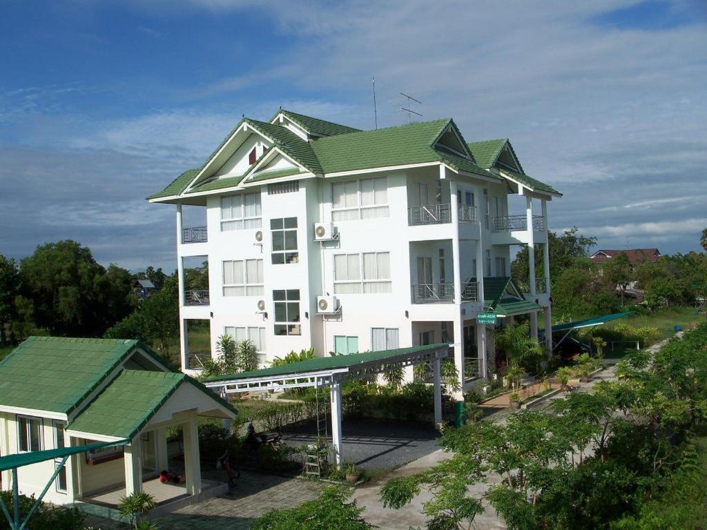 Ban Nong TaoKasem Garden Hotel Surin的一座白色的大建筑,设有绿色屋顶