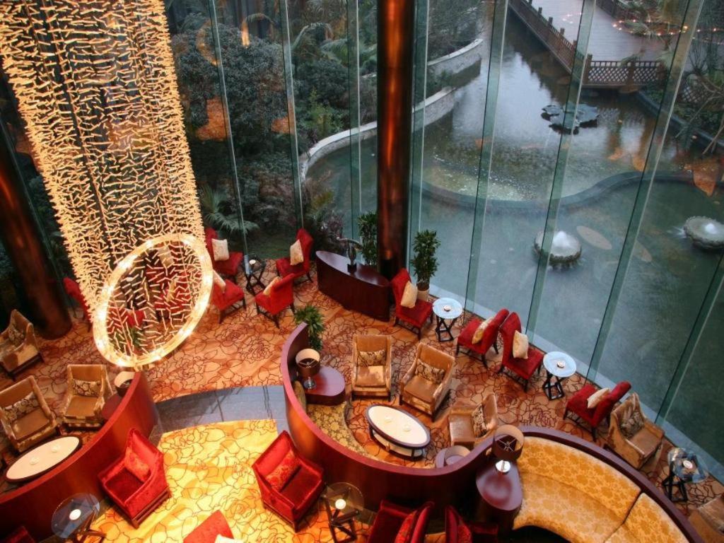 双流Sichuan Tennis International Hotel Main Building的一间带桌椅和游泳池的餐厅
