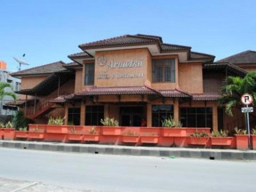 BorukuHotel Arumbai的大楼前的一间餐厅,配有红色椅子
