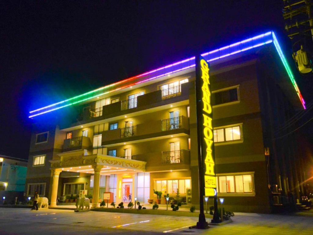 奥隆阿波Grand Hoyah Hotel的一座晚上有彩色灯光的建筑