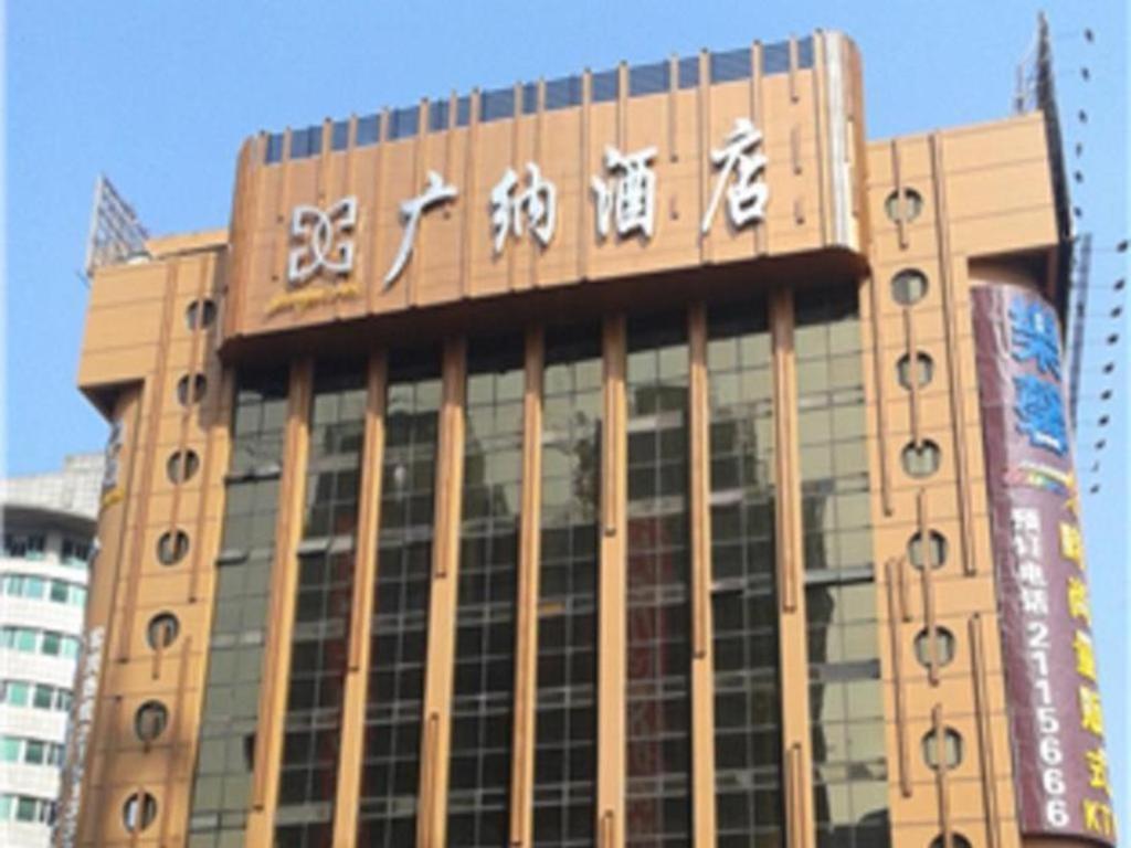 惠州Guangna Hotel的建筑的侧面有中国文字