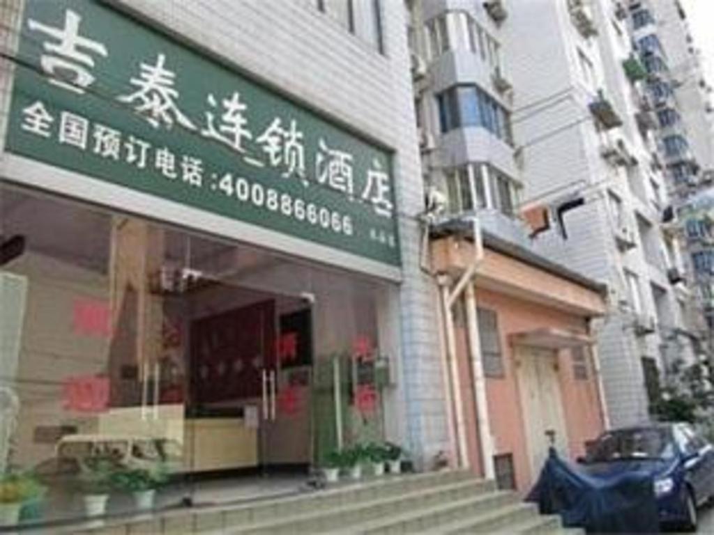 上海Jitai Hotel Shanghai Yangpu Benxi Hospital Branch的建筑物一侧有标志的商店