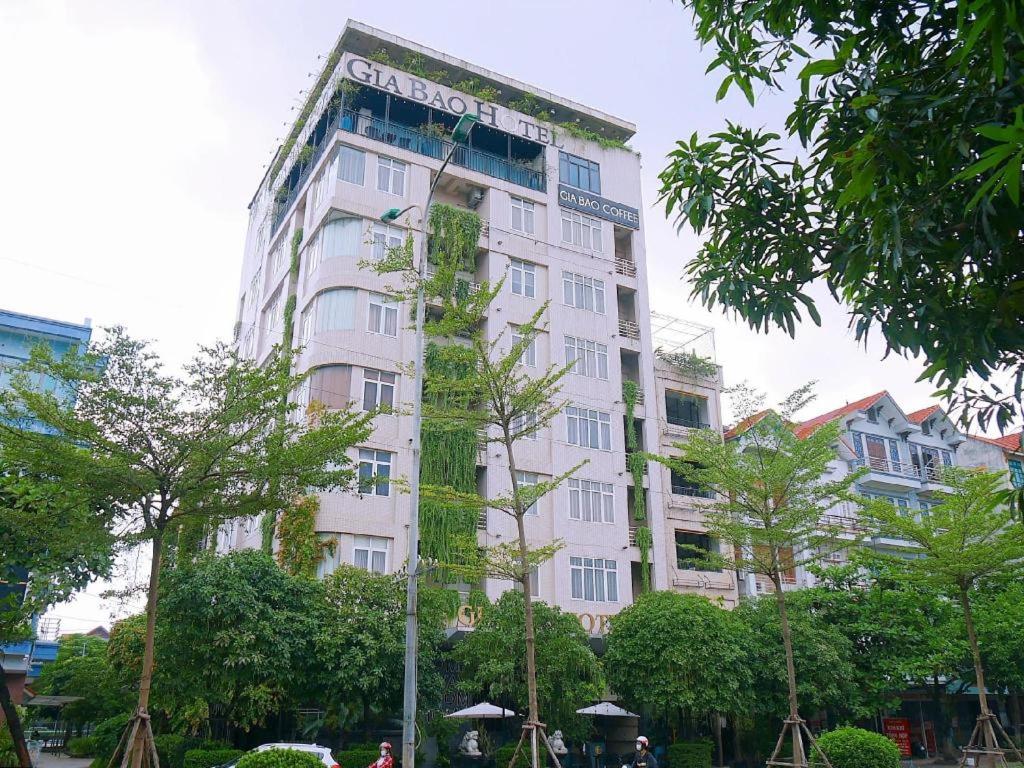 Ða HộiGia Bao Hotel Bac Ninh的一座高大的白色建筑,上面有标志