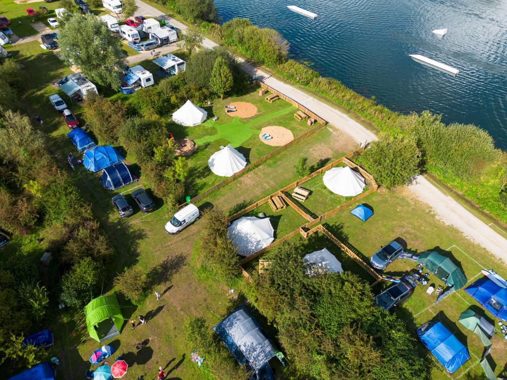 诺丁汉Spring Lakes Lake Side Bell Tents的一组帐篷和水边的营地的空中景观