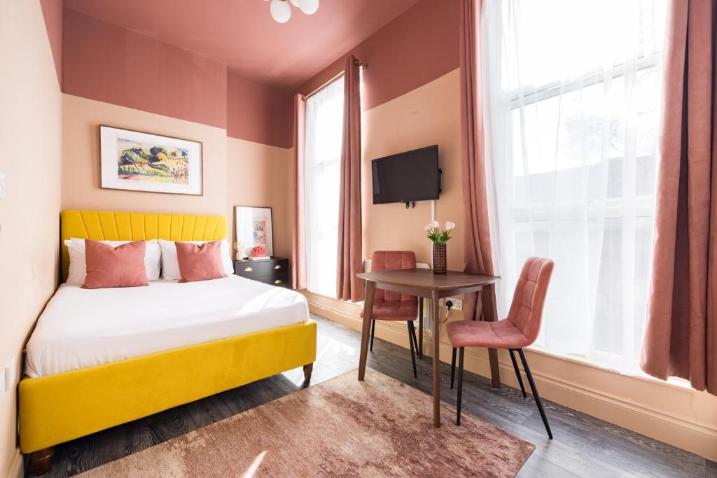 伦敦Euston apartments的酒店客房设有一张床、一张书桌和一台电视机。
