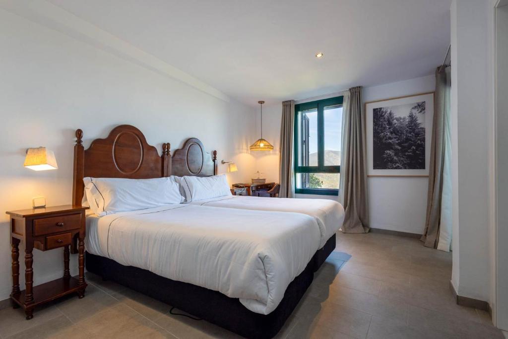 扎哈拉Hotel Tugasa Arco de la Villa的一间卧室设有一张大床和一个窗户。
