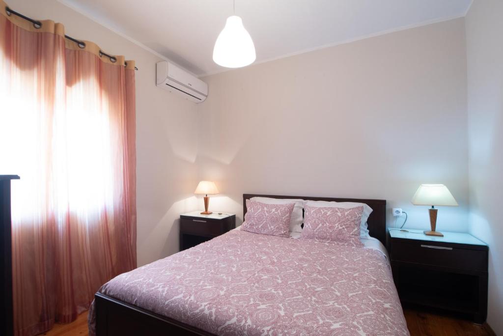 莱萨·达·帕尔梅拉PortoMar House Apartament的一间卧室配有一张床、两盏灯和一个窗户。