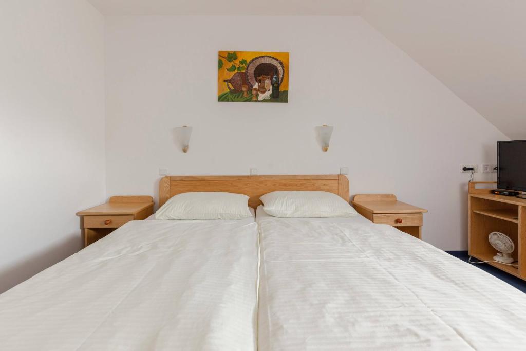 PernicaTuristična kmetija Protner的一间卧室配有一张带白色床单的床和一台电视。
