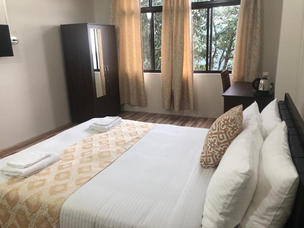 甘托克Payong House的卧室配有一张带白色床单和枕头的大床。