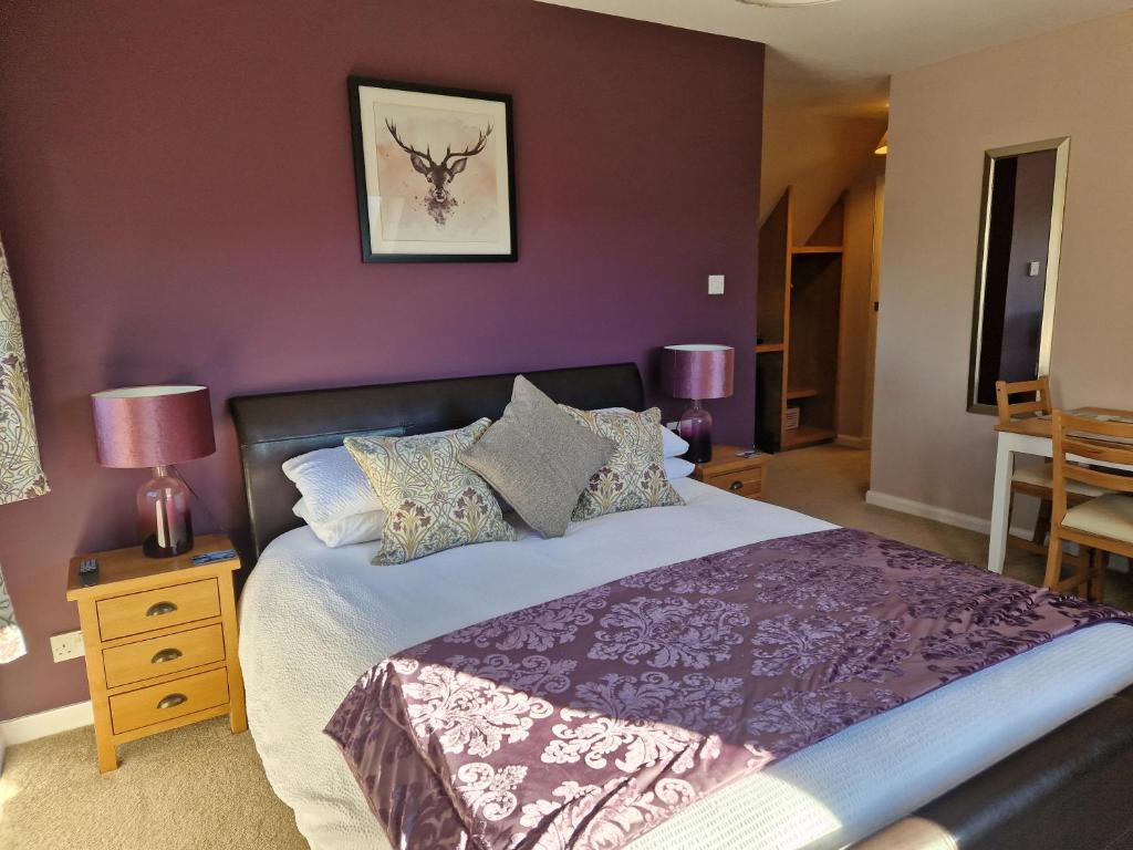 阿勒浦Croft 17的一间卧室设有一张紫色墙壁的大床