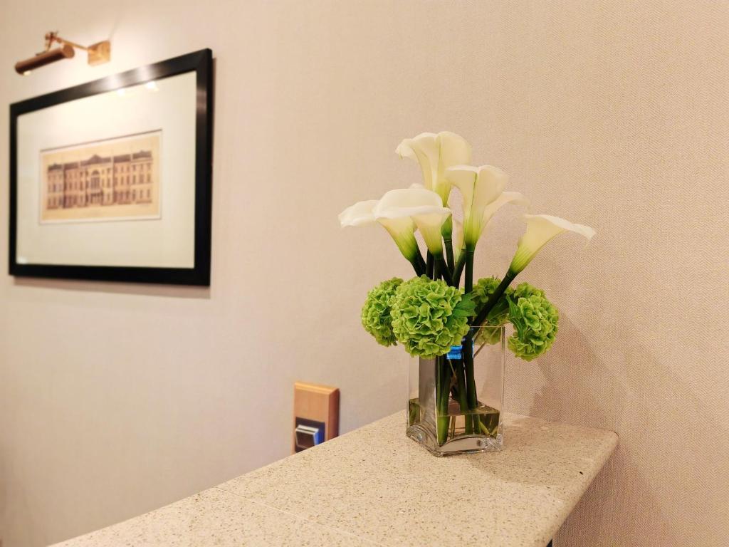 爱丁堡弗雷德里克大楼酒店的花瓶,花瓶上满是白色的花,坐在柜台上