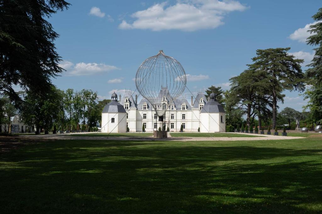 卡尔克富Château de Maubreuil的一座大型白色建筑,顶部有大球