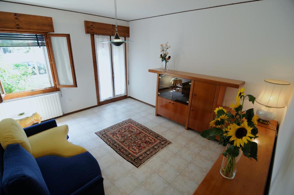 巴塔利亚泰尔梅Appartamento Colli & Terme的客厅配有蓝色的沙发和花瓶