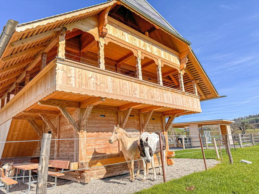 吕策尔弗吕Ferienhaus Spycher im Emmental的站在木结构前的牛