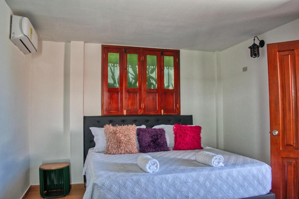 圣玛尔塔Hotel Casa Bethel的一间卧室配有带色彩缤纷枕头的床。