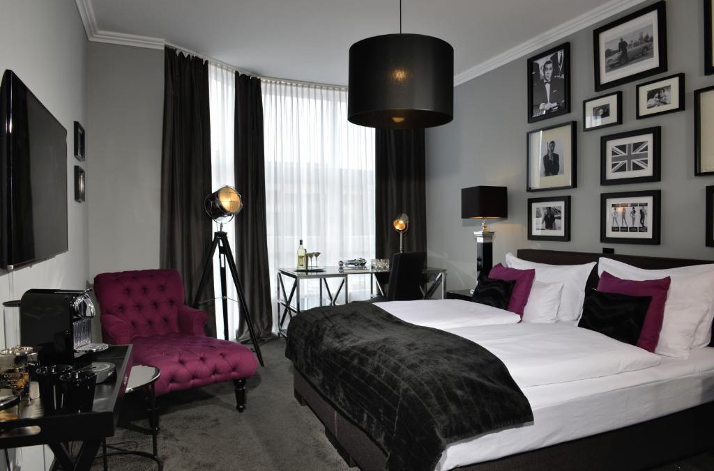 许克尔霍文许克尔霍文友好酒店的一间卧室配有一张大床和一张紫色椅子