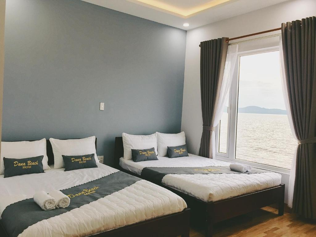 岘港DanaBeach Motel的带窗户的客房内的两张床