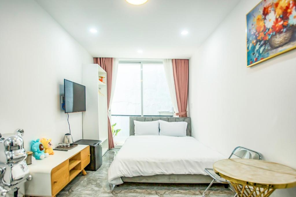 胡志明市Le Vu Hotel的一间卧室配有一张床、一张桌子和一台电视