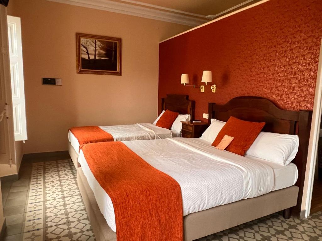 锡切斯瑙赛迪斯塔酒店的红色墙壁的酒店客房内的两张床