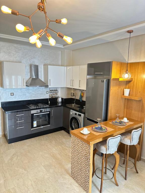 穆罕默迪耶Appartement confortable et pas cher au parc的厨房配有桌子、炉灶和冰箱。