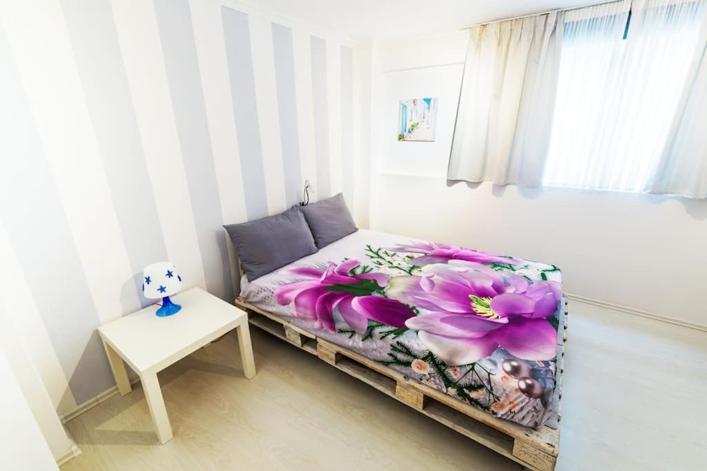 雅典2 Bedrooms Apartment close to metro Dafni in Athens的一间卧室配有一张带紫色花毯的床