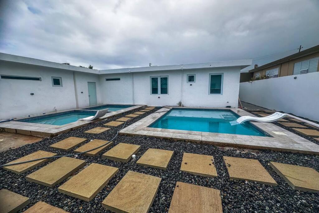阿雷西博Centrally located Villa with 3 Pools -Food & Beach walking distance的一座建筑后院的游泳池