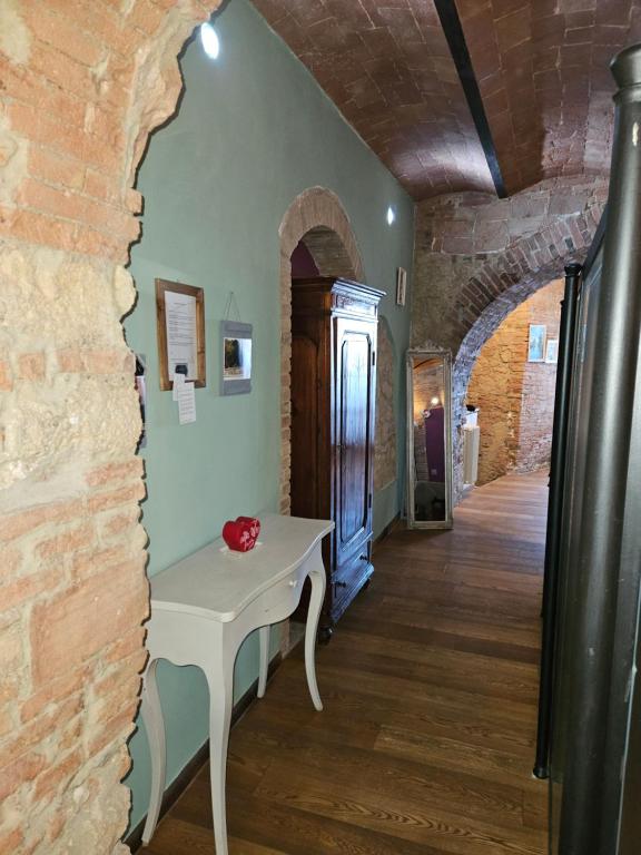 波马兰切Bella Toscana的一间设有桌子和砖墙的房间