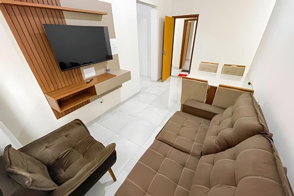 帕图斯迪米纳斯104 - Apartamento Completo para até 7 Hóspedes的带沙发和平面电视的客厅