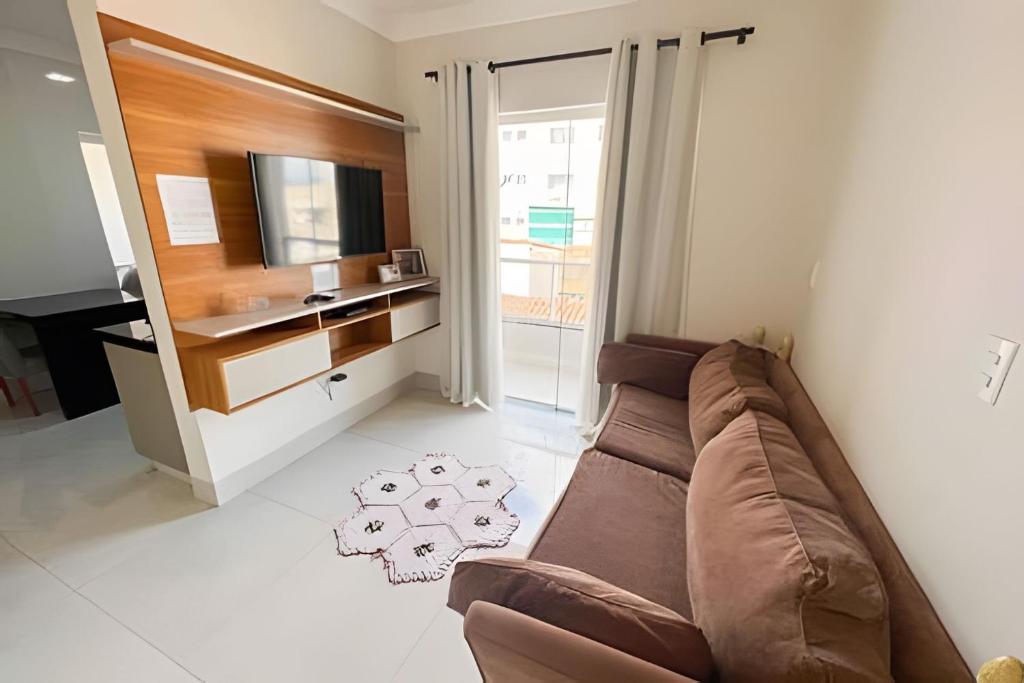 帕图斯迪米纳斯M203- Apartamento c/ Suíte Completo Patos de Minas的客厅配有棕色沙发和电视