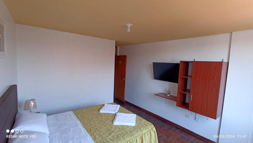 塔克纳Montecristo Hotel的一间酒店客房,配有一张床和一台电视
