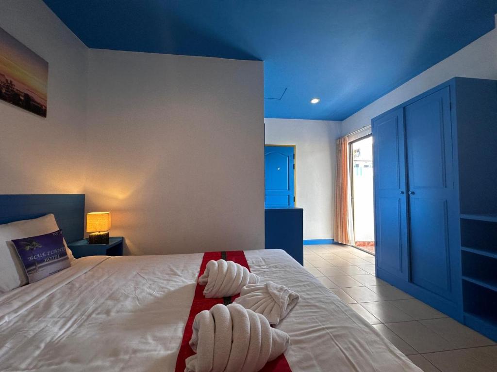 芭东海滩Tuna Boutique Hotel的一间卧室设有一张蓝色天花板的大床