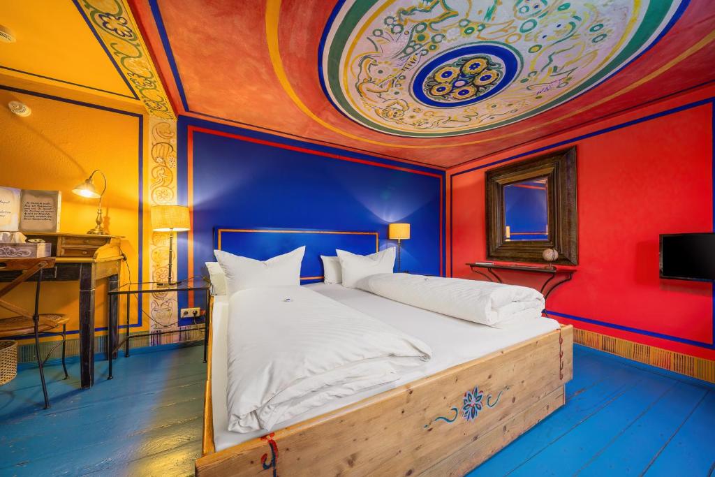 德累斯顿坎帕尼奥拉膳食公寓及餐厅的一间卧室配有一张蓝色和红色墙壁的床