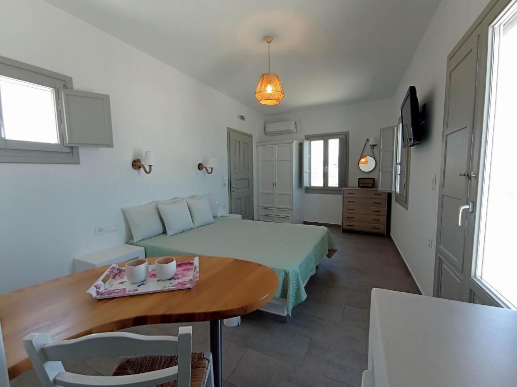 Áno MeriáSeascape, Suite 5 with sea view的一间卧室配有床和桌子,上面有杯子