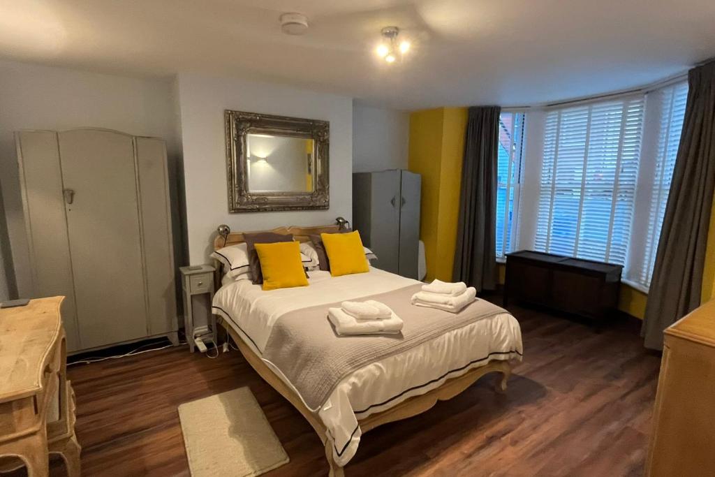 斯卡伯勒Seaside Hideaway - Free Onstreet Parking的一间卧室配有一张带两个黄色枕头的床