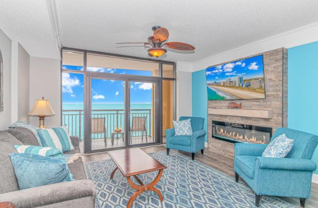 默特尔比奇Stunning Double Balcony- Oceanfront 2 Bedroom, 2 Bath- Anderson Ocean Club 905的带沙发、椅子和壁炉的客厅