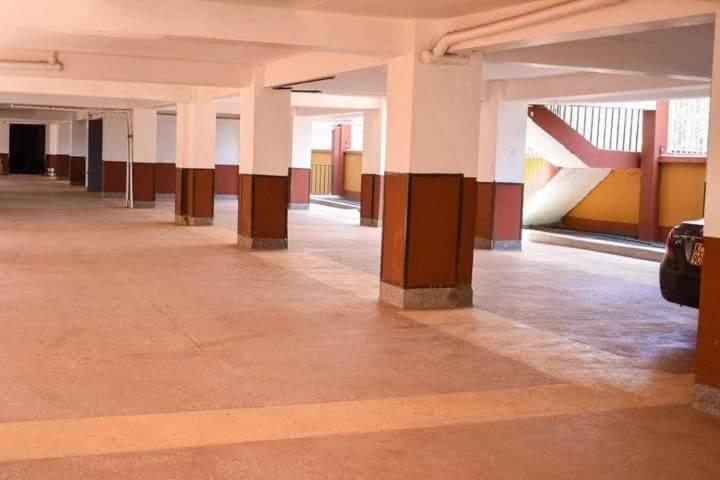 内罗毕Garden estate thika road的建筑中空的走廊,有圆柱和桌子