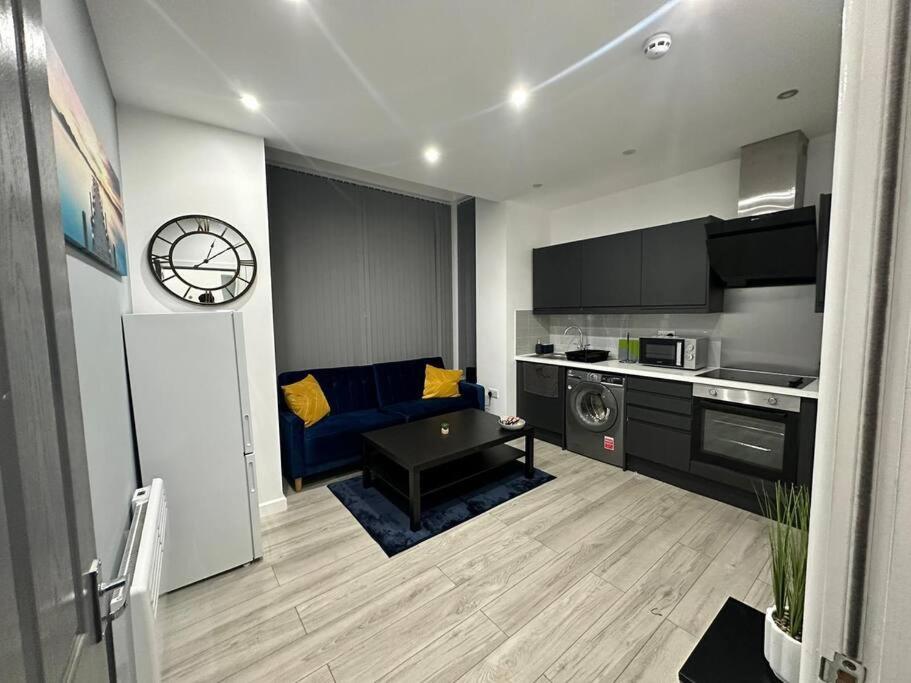 Beeston HillLuxurious 2 bedroom flat的客厅配有蓝色的沙发和时钟