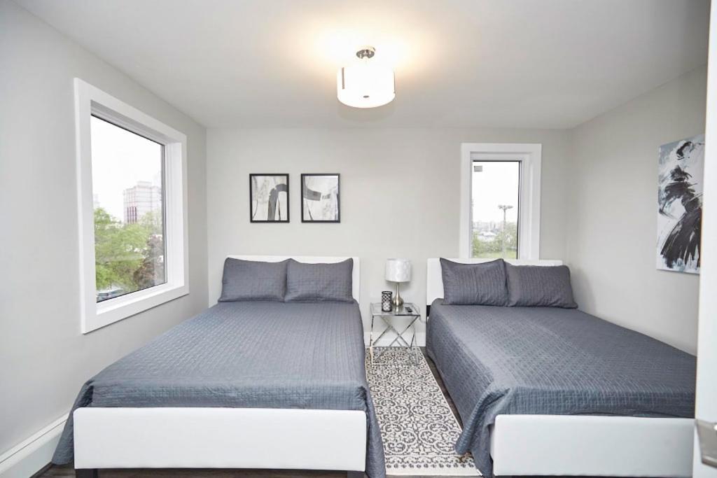 尼亚加拉瀑布Clifton Hill Hideaway 3A - Two Bedroom Condo的白色客房的两张床,设有两扇窗户