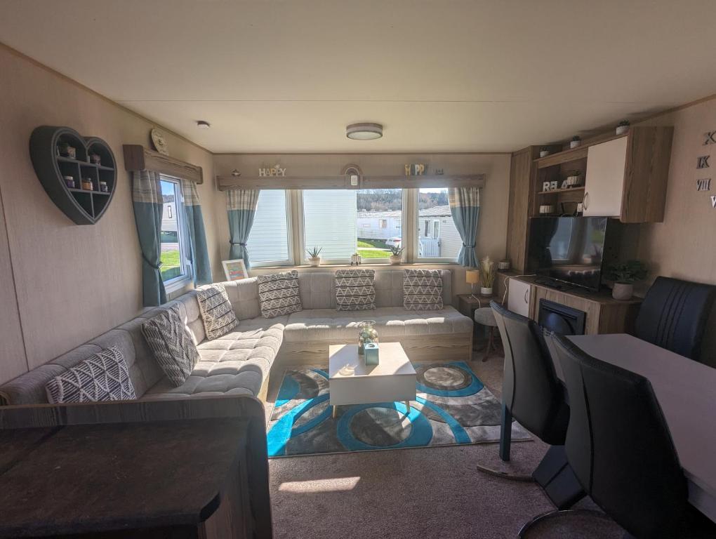 Wyke RegisCaravan sleeps 8 at Littlesea, Weymouth的客厅配有沙发和桌子