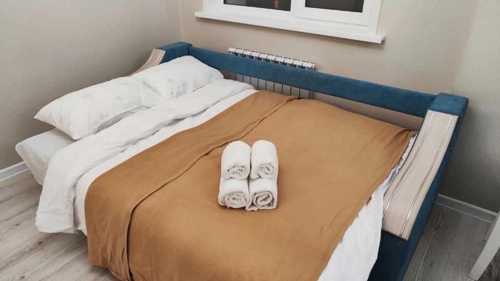 PrigorodnyyKamal Apart的一张医院床,上面有两双鞋