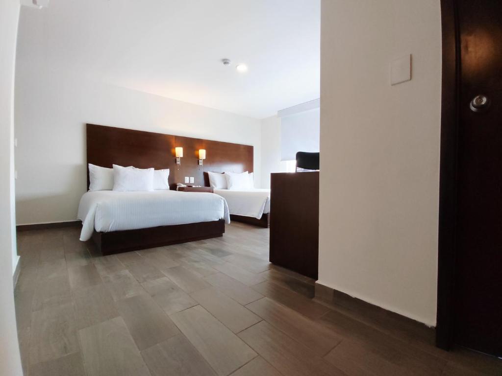 坦皮科Ramada by Wyndham Tampico Centro的酒店客房配有两张床和一张书桌