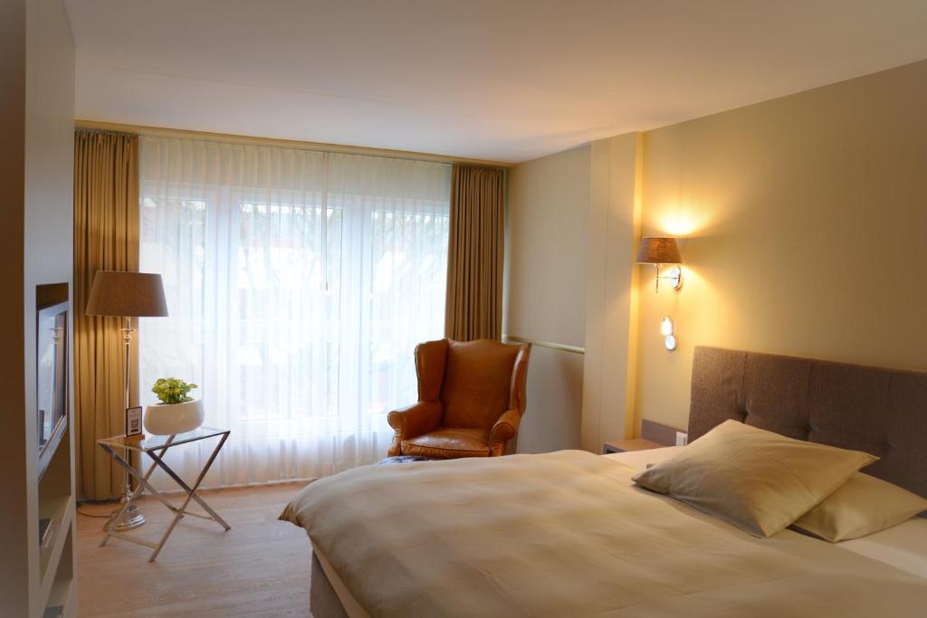 朗根塔尔朗根塔尔公园酒店的卧室配有床、椅子和窗户。