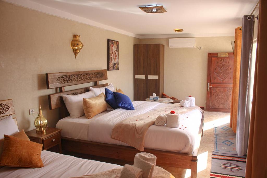 瓦尔扎扎特Maison D'hôtes IMINIGRAN & Spa的一间酒店客房,设有两张床和一扇门