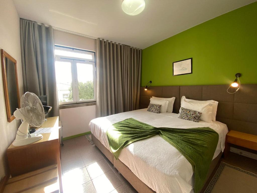 奥尔塔豪斯佩达日雅维尔德玛尔酒店的一间卧室配有一张带绿色墙壁的床