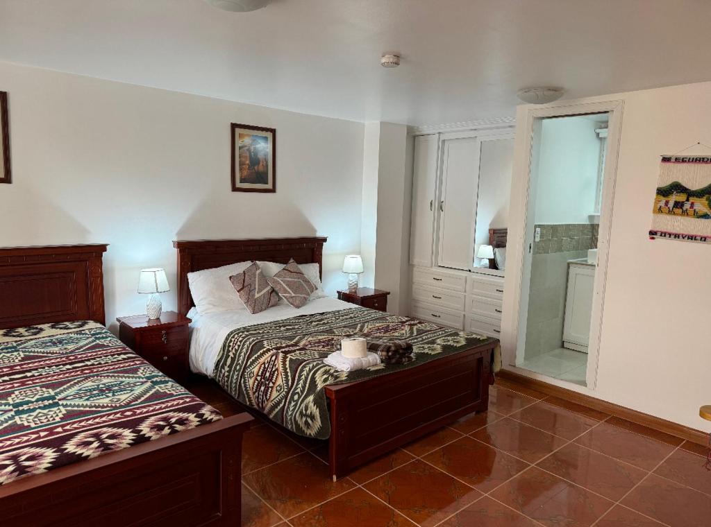 奥塔瓦洛Kimsa Wasi III的一间卧室设有两张床和窗户。